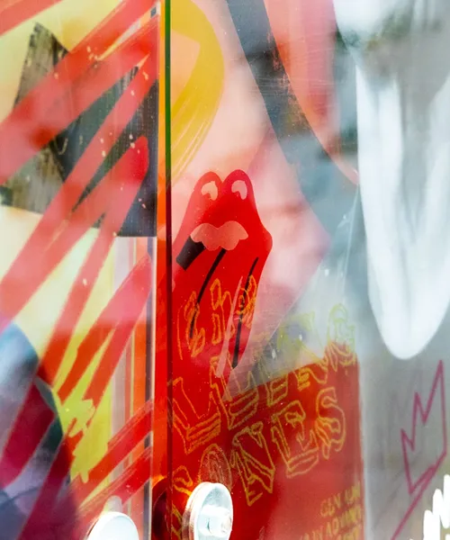 Bunte Wandgestaltung mit rotem Mundmotiv und abstrakten Farbflächen in lebhaften Tönen.