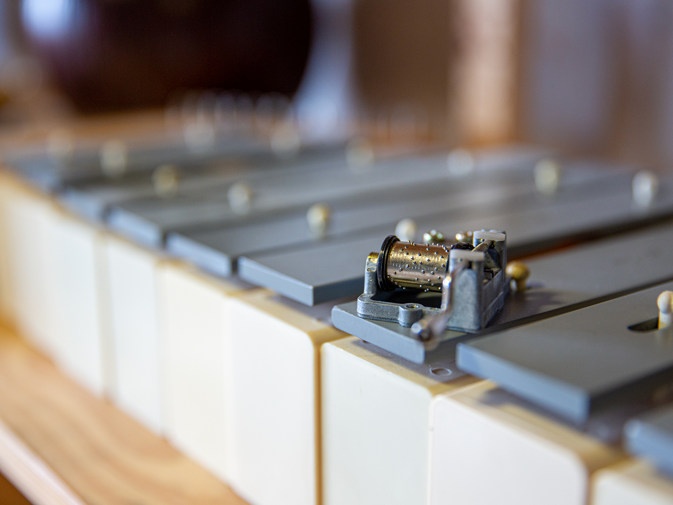 Nahaufnahme eines Metallxylophons mit einem kleinen Spieluhr-Mechanismus im Vordergrund.