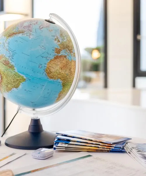 Nahaufnahme eines Globus mit Fokus auf den Atlantischen Ozean, im Hintergrund ein heller Raum mit Fenstern.