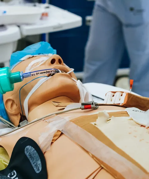 Medizinische Übungspuppe mit Beatmungsschlauch und Infusion für Notfall- oder Intensivsimulation.